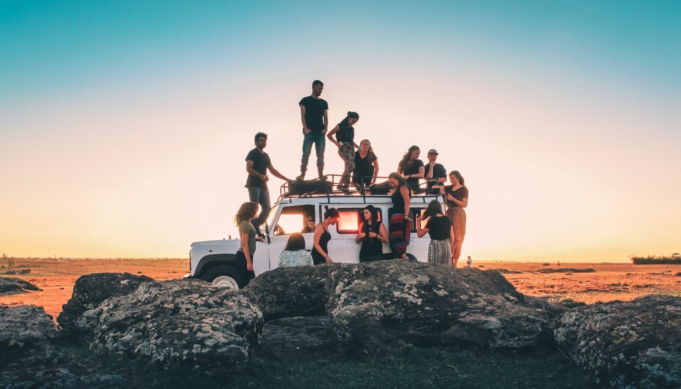 group of people sitting on white car during daytime