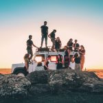 group of people sitting on white car during daytime