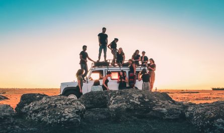 group of people sitting on white car during daytime