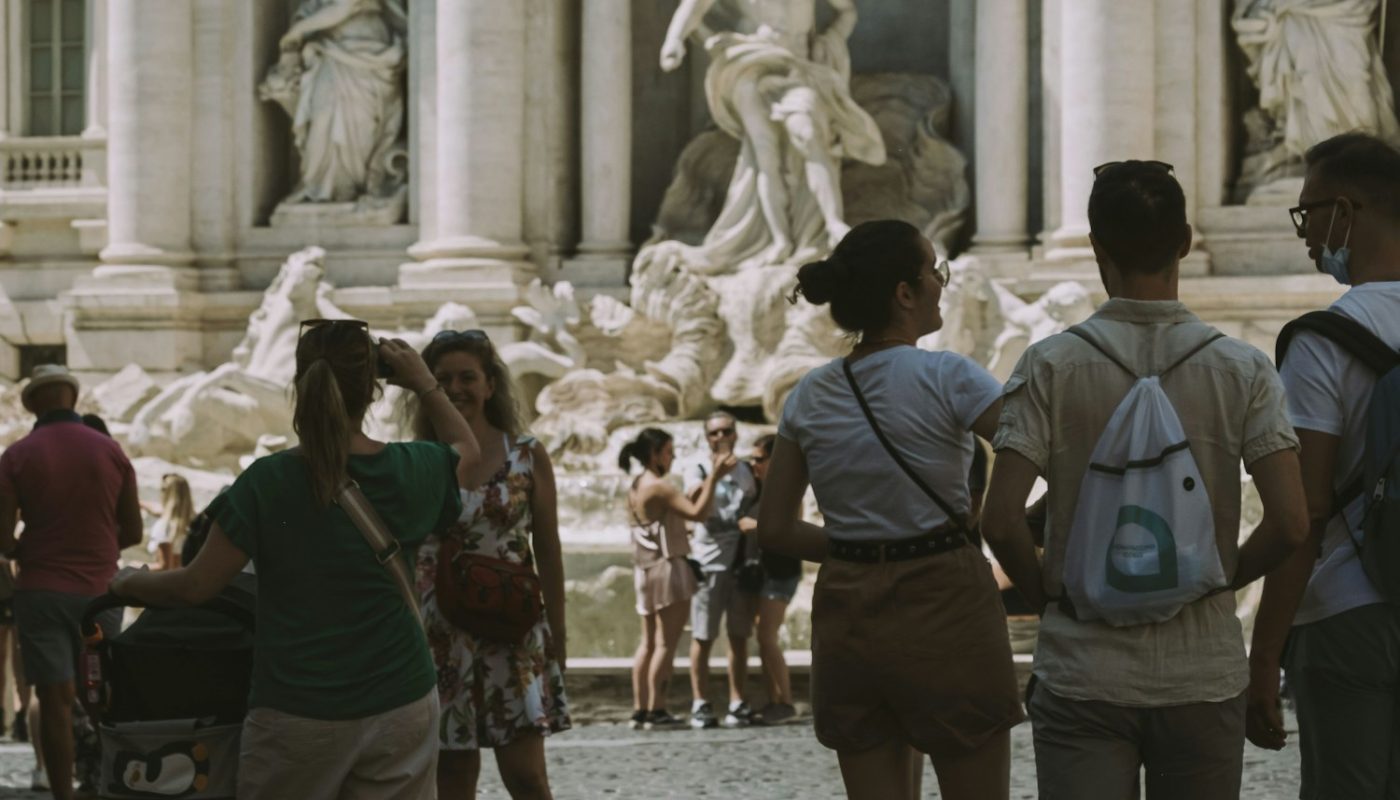 people walking on street near statue during daytime