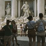 people walking on street near statue during daytime