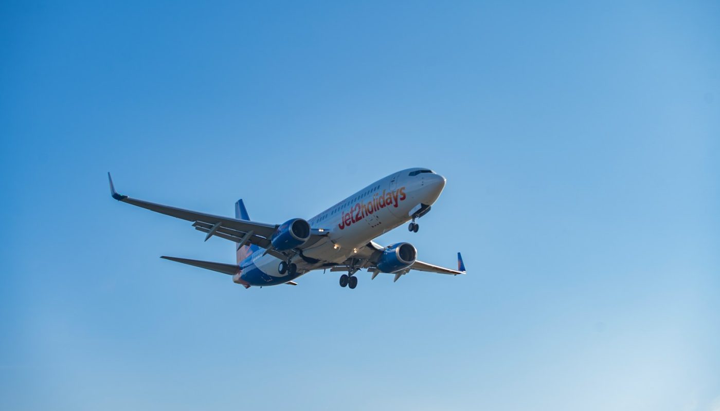 A commercial airplane flying in a clear blue sky.