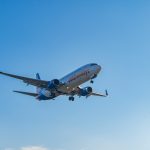 A commercial airplane flying in a clear blue sky.