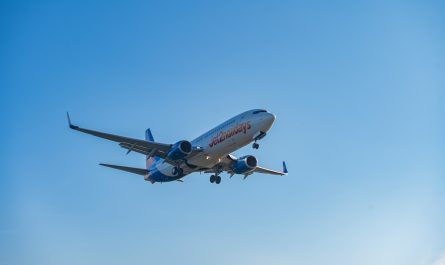 A commercial airplane flying in a clear blue sky.