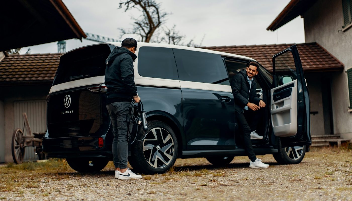 a couple of men standing next to a van