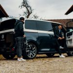 a couple of men standing next to a van