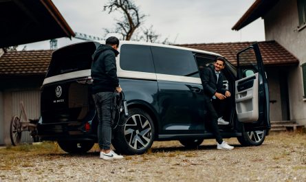 a couple of men standing next to a van