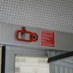 Red emergency handle and warning sign on a train.