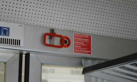 Red emergency handle and warning sign on a train.