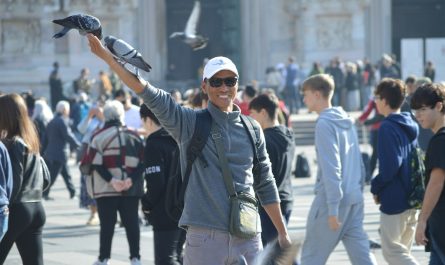 A man with a bird on his arm in the middle of a crowd of people